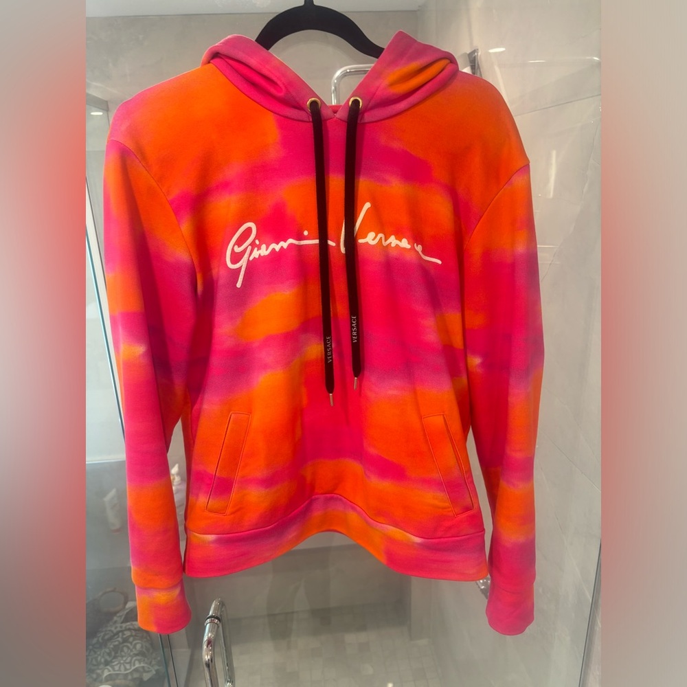 Versace sweater. Orange and pink. It’s like a woman small.